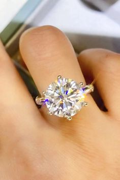 a woman's hand with a diamond ring on it