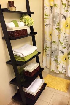 a shelf with towels and baskets on it in a bathroom next to a shower curtain