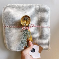 a person is holding a christmas present wrapped in twine