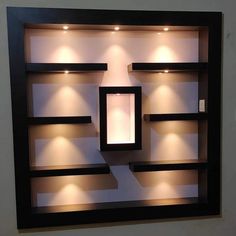 a wall mounted shelf with lights on it and some shelves in the middle that are made out of wood