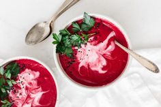 two bowls of beet soup with spoons on the side