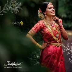 a woman in a red sari is smiling and holding her hands to her face