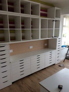 an empty room with white cabinets and drawers