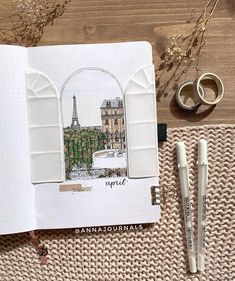 an open notebook with a drawing of the eiffel tower in paris on it