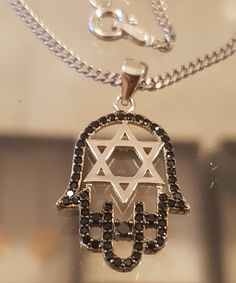 Large 925 silver black hamsa pendant with Star of David .  Beautiful hamsa made of silver 925 and tiny inlaid Black zircons white , smooth star of David ,combined with a smooth Star of David and a sparkling hamsa that is studded with small zircons beautiful textur which gives a shiny and luxurious look This beautiful necklace is  elegant and impressive charm pendant to wear for good luck   and protection . The pendant is thick and attached to a beautiful, elegant, sparkling chain made of Italian 925 silver                          The necklace will be sent beautifully packaged and ready to be given as a gift * Free Shipping About me: https://www.etsy.com/il-en/people/rutyawpaloma David Belle, Hamsa Design, Hamsa Pendant, Hamsa Necklace, Family Jewels, Luck Charm, Luck Charms, Star Of David, Beautiful Necklace