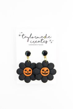 two black and orange flower shaped earrings on top of a white card with the words, stay