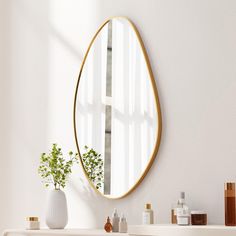 a mirror on the wall above a sink in a room with white walls and furniture