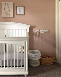 a baby's room with a crib and pictures on the wall