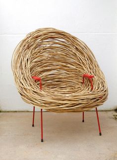 a wicker chair sitting on top of a cement floor next to a white wall