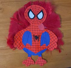 a paper cut out of a spiderman with red feathers on the bottom and blue eyes