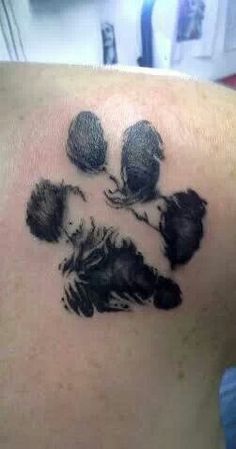 a black ink tattoo on the back of a woman's shoulder with three bears paw prints