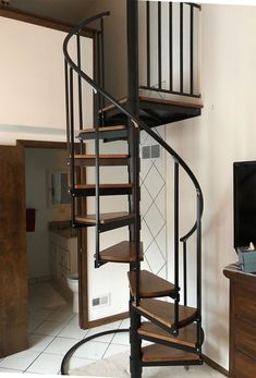 there is a spiral staircase in the living room with tile flooring and white walls