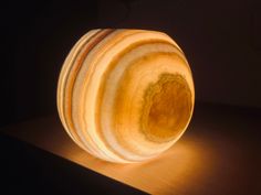 a wooden object sitting on top of a table with a light shining through the center