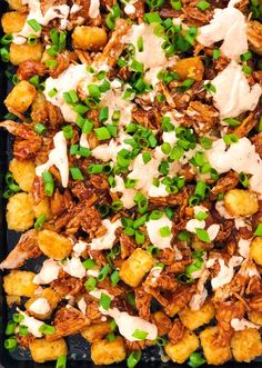 a tray filled with meat and vegetables covered in ranch dressing on top of green onions