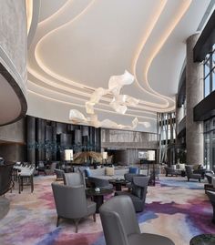 a large lobby with chairs, tables and lamps on the ceiling is lit by lights that look like swirls