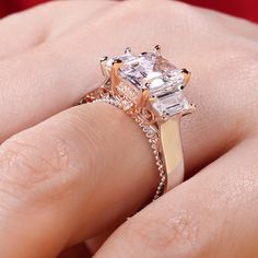 Luxurious and breathtaking, this engagement ring honors the light of your life. Crafted in two tone sterling silver, the ring features an emerald-cut center stone accented with two taper baguette-cut stones on a high polished shank. The shank is buffed to show a bright shine and elegant look. The delicate rose gold tone filigree details on the side of the ring adds elegance and vintage aesthetics to it. Surprised her with this masterpiece!Carat Weight: 3.85 ctStone Size: 7*9 mmStone Type: Jeulia Emerald Cut Baguette Diamond Promise Jewelry, Square Cut Emerald Ring With Accent Stones For Wedding, Silver Promise Ring With Baguette Diamonds, Silver Square Cut Baguette Diamond Ring, Silver Wedding Ring With Asscher Cut Accent Stones, Square-cut Emerald Ring With Diamond Cut For Wedding, Square Cut Emerald Ring With Diamond Detail For Wedding, Emerald Asscher Cut Ring With Baguette Diamonds For Wedding, Promise Ring With Asscher Cut And Accent Stones