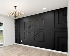 an empty room with black painted walls and wood flooring is seen in this image