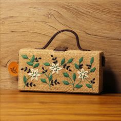 Elevate your style with this handcrafted Garden Embroidered Jute Handbag. Featuring intricate floral designs in vibrant greens and whites, this eco-friendly accessory blends rustic charm with timeless elegance. The natural jute fabric and detailed embroidery create a perfect fusion of sustainability and sophistication. Ideal for casual outings, this unique handbag adds an earthy, artistic touch to any look while staying fashionably functional. Jute Handbags, Unique Handbag, Eco Friendly Accessories, Jute Fabric, Detailed Embroidery