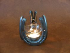 a small glass candle holder sitting on top of a wooden table next to a wall