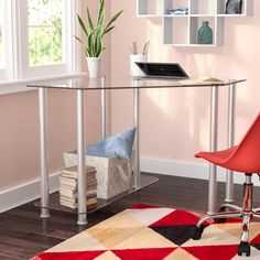 a desk with a red chair in front of it and a rug on the floor