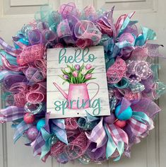 a pink and blue wreath with the words hello spring on it