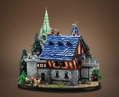 a model of a castle with trees and animals on it's roof, in front of a brown background