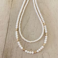 This necklace is a beautiful piece to wear for a minimalist look and a great basic for layering. Potato shaped white freshwater pearls and adorned with gold spacer beads. Length 16" extender 2" Small fresh water seed pearls adorned with 2mm gold beads. Length 19" According to history and the myths, pearls are believed to attract good luck and wealth. Solar Plexus/Sacral Chakra. -This information is intended for spiritual support only- Tips: it is recommended keeping your necklace away from perfu White Pearl Beaded Necklaces For Layering, Dainty White Double Strand Pearl Necklace, White Pearl Layering Necklaces, White Pearl Drop Necklace For Layering, Delicate White Double Strand Pearl Necklace, White Delicate Pearl Necklace For Layering, Delicate White Pearl Necklace For Layering, White Double Strand Pearl Drop Beaded Necklaces, White Double Strand Pearl Charm Beaded Necklace