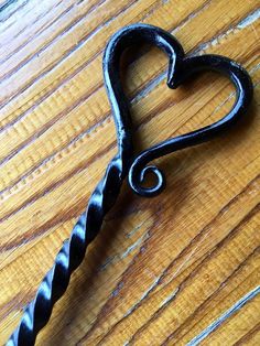 a heart shaped metal hook on a wooden table