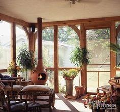 the sun room is filled with potted plants