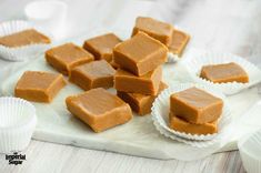 several pieces of peanut butter fudge sitting on top of a white paper plate next to cups