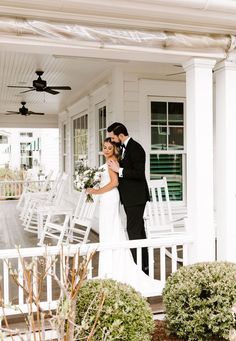 a bride and groom standing on the porch of their home