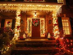 a house with christmas lights and wreaths on the front porch