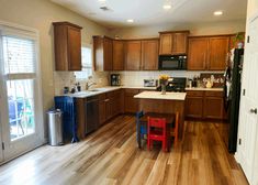 a kitchen with wooden floors and brown cabinets