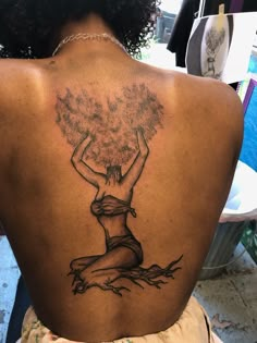 a woman with a tree tattoo on her back