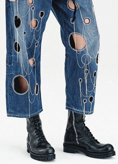 a man in ripped jeans with holes and chains on his pants