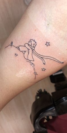 a person with a small tattoo on their arm that has a drawing of a girl holding a star