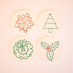 four coasters decorated with christmas designs on white paper and colored ink, sitting next to each other