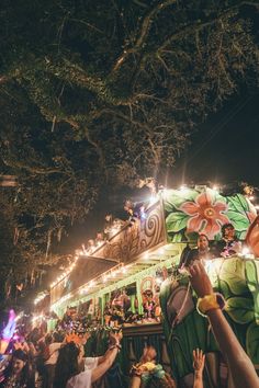 a group of people standing in front of a float with lights on it's sides