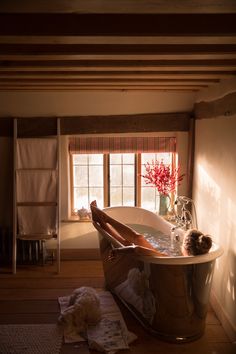 a woman laying in a bathtub with her feet up on the floor next to a window