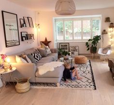 a living room with furniture and pictures on the walls, including a baby sitting on a rug