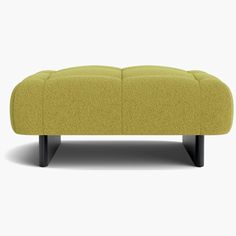 a yellow ottoman sitting on top of a white floor