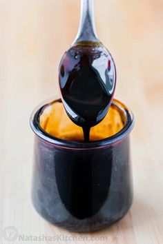 a spoon full of syrup sitting on top of a black container