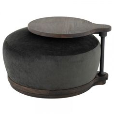 a round ottoman with a wooden top and black velvet upholstered cushion on it