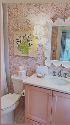 a bathroom with pink and white wall paper