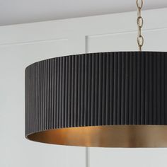 a black and gold chandelier hanging from a ceiling fixture in a room with white walls