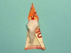 an origami santa clause hanging from a string on a blue background with the word joy written below it