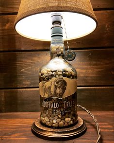 a lamp that is sitting on top of a table next to a bottle with rocks in it