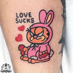 a person with a tattoo on their leg that says love sucks and an image of a cat