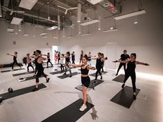 a group of people doing yoga in a large room