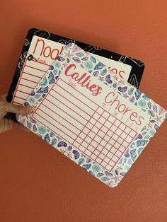 a person holding up two notebooks with writing on them that say no calies